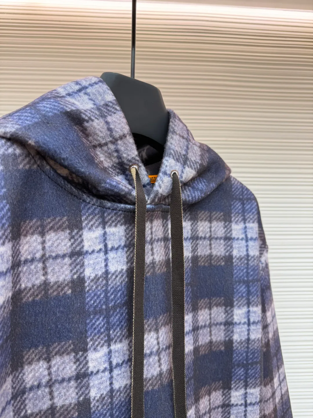 LOUIS VUITTON plaid gradient long-sleeved hoodie ●Original version: Purchased and developed for 15100 ●Item number: 1681896-B40 ●Fabric: wool blended fabric ●Technology: Digital direct printing ●Color: Purple ●Version: Fitted version ●Weight: about 1035 grams ●Size: S-M-L-XL ●Description: This hooded sweatshirt uses splicing technology to create a layered texture: the upper part is made of wool blended fabric with a blue and gray plaid pattern, and is pre-shrunk to ensure a stable fit; the lower part and sleeves use digital printing technology to present a gradient Monogram dark pattern, and the ink penetrates the fiber to achieve high color fastness. The hood has a built-in invisible lining to enhance stiffness, and the drawstring is made of wear-resistant nylon rope with a metal bell for smooth pulling. The front kangaroo pocket is made of welted bag technology, and the edge of the bag mouth is reinforced with double stitching. The cuffs and hem are made of ribbed knitted fabric, and the elastic hemming fits the body shape. The seams throughout the garment are high-strength stitches of the same color. Precision sewing every 3cm/12 stitches improves durability. The overall craftsmanship takes into account both visual details and practical durability. The overall wiring is straight and delicate, the fabric is comfortable and soft, and the color is consistent without color difference. It can be matched with the same style to create a fashionable look and control various occasions. Customized accessories, complete with three standards, same style for men and women!